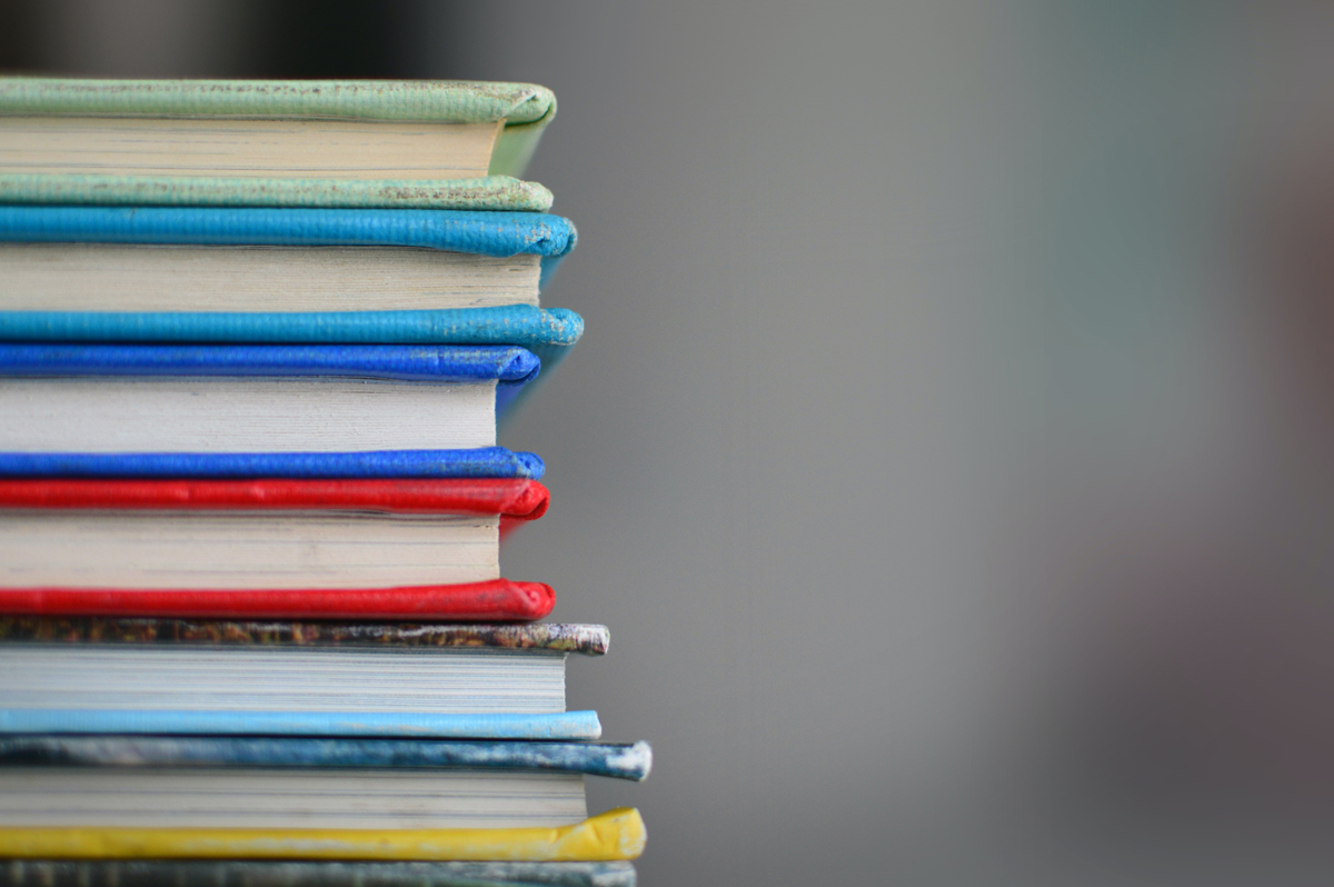 A side view of a pile of multi-coloured books